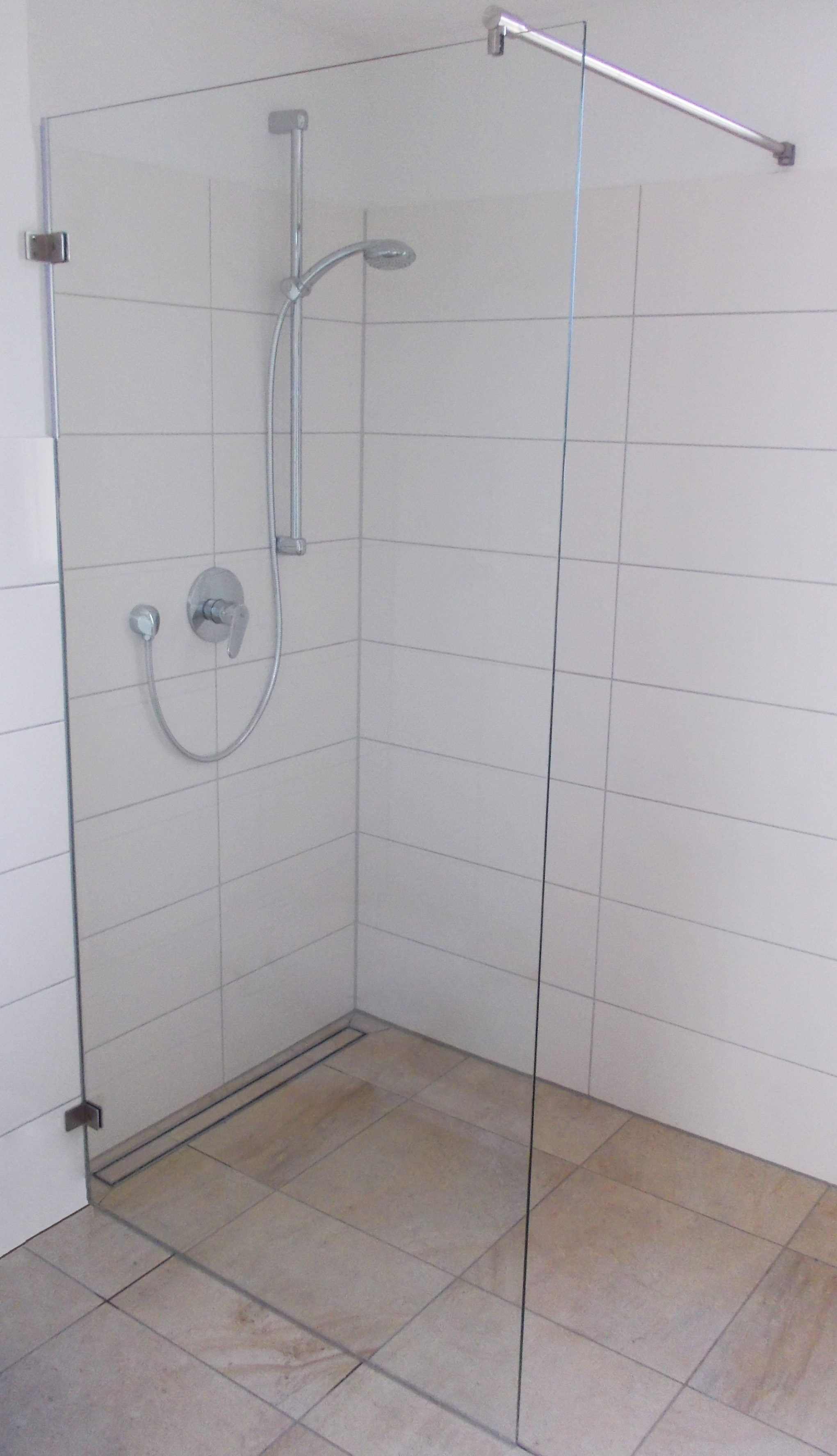 Realistic photograph of actual curbless walk-in shower with spatial dimension markers.