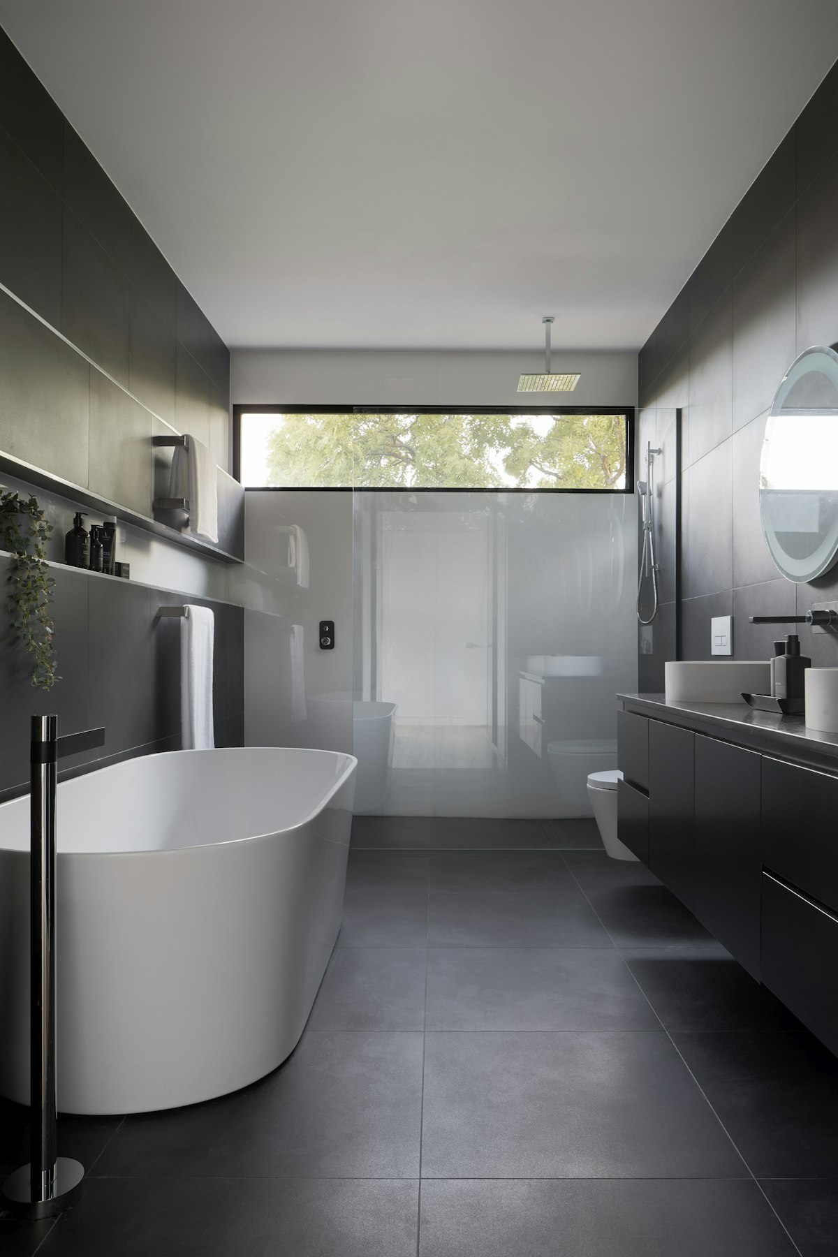 Modern master bathroom with freestanding soaking tub, floating double vanity, and seamless walk-in shower.